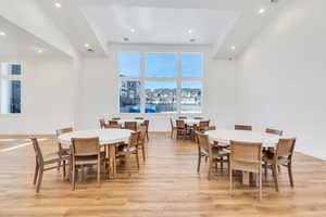 Dining area featuring light wood-type flooring, recessed lighting, and a high ceiling