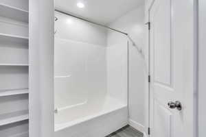 Bathroom featuring shower / bath combination, a closet, and recessed lighting
