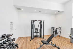 Workout room featuring light wood-style floors and recessed lighting