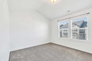 Unfurnished room featuring light carpet and baseboards