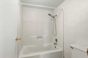 Full bathroom featuring shower / tub combination and toilet