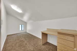 Additional living space featuring vaulted ceiling and light carpet