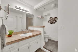 Bathroom with ornamental molding, vanity, and light tile patterned flooring