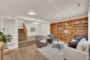 Living area featuring wood finished floors and crown molding