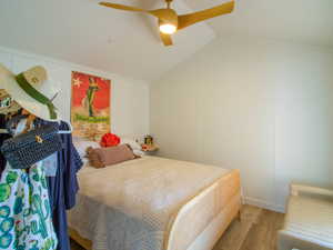 Bedroom with wood finished floors, ceiling fan, and lofted ceiling
