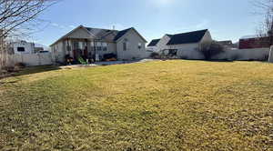 Rear view of property with a gate, a fenced backyard, a patio, and a playground