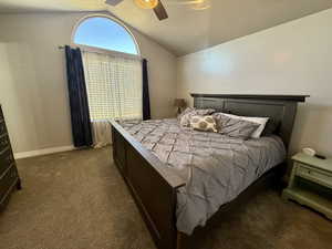 Bedroom featuring dark colored carpet, a textured ceiling, and ceiling fan