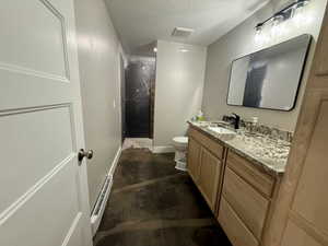 Bathroom featuring vanity, a stall shower, finished concrete flooring, a baseboard radiator, and a textured ceiling