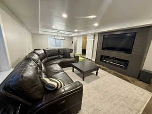 Living room featuring a large fireplace, recessed lighting, and a textured ceiling