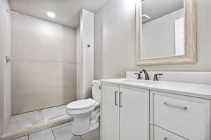 Bathroom with vanity, light tile patterned flooring, and recessed lighting