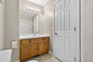 Bathroom featuring vanity, light tile patterned floors, and a shower