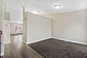 Unfurnished room featuring baseboards and dark wood-type flooring