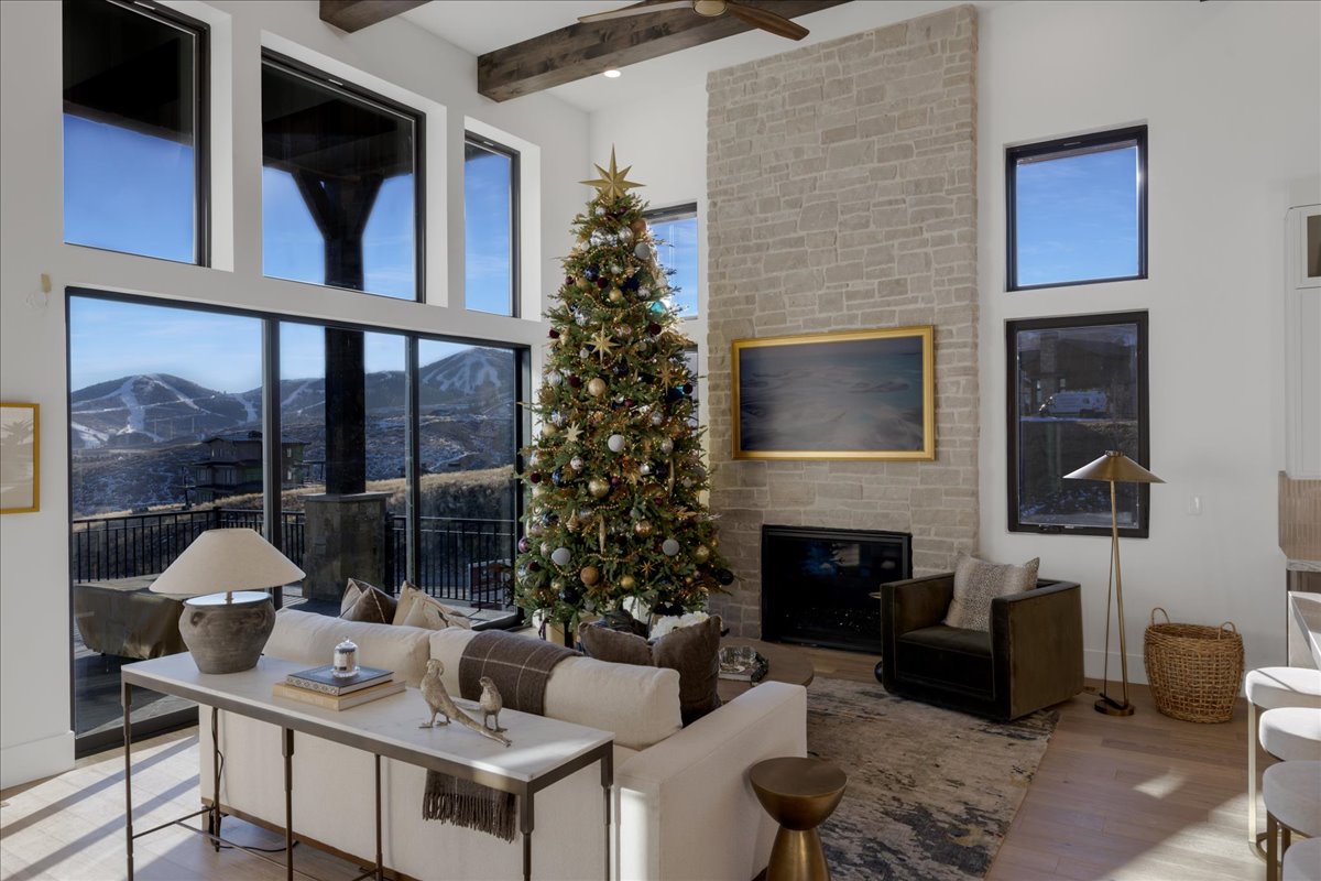 Living area featuring a fireplace, a mountain view, wood finished floors, and a ceiling fan