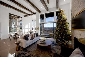 Living room featuring healthy amount of natural light, wood finished floors, a stone fireplace, and recessed lighting