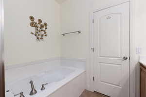 Full bathroom featuring a garden tub and vanity