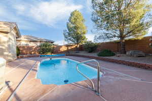 View of pool featuring patio surround and a fenced backyard
