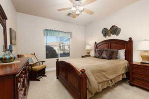 Bedroom with light colored carpet and a ceiling fan