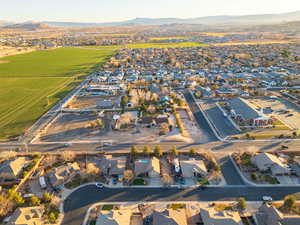 Aerial view of property and surrounding area with a mountainous background and nearby suburban area