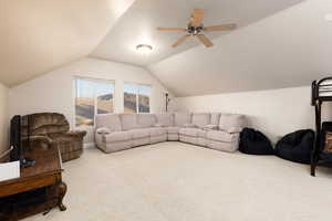 Carpeted living room featuring a ceiling fan