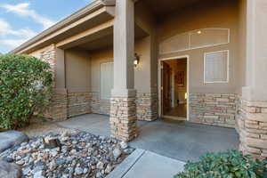 Doorway to property with stone siding and stucco siding
