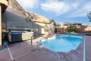 View of swimming pool with a fenced backyard, patio surround, and a hot tub