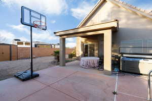 Fenced backyard featuring a patio area and a shed