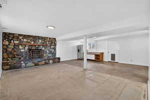 Finished basement with a fireplace and stainless steel fridge