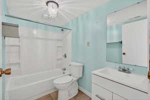 Bathroom with vanity, shower / washtub combination, light tile patterned floors, a chandelier, and a textured ceiling