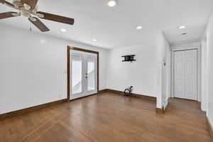 Spare room with dark wood finished floors, french doors, ceiling fan, and recessed lighting