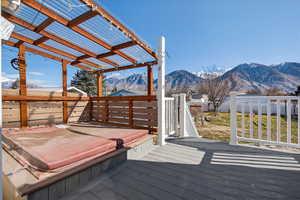 Wooden deck with a covered hot tub and a mountain view