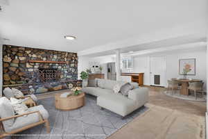 Living area featuring concrete flooring and a stone fireplace