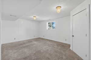 Unfurnished bedroom featuring light carpet and baseboards