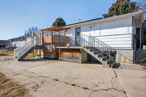 Back of property with stairway and a wooden deck