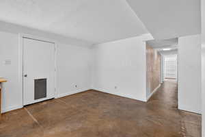 Spare room featuring finished concrete flooring and a textured ceiling