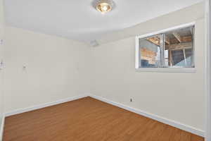 Spare room with vaulted ceiling and wood finished floors