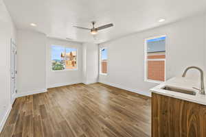 Unfurnished living room featuring wood tiled floors, a ceiling fan, and recessed lighting