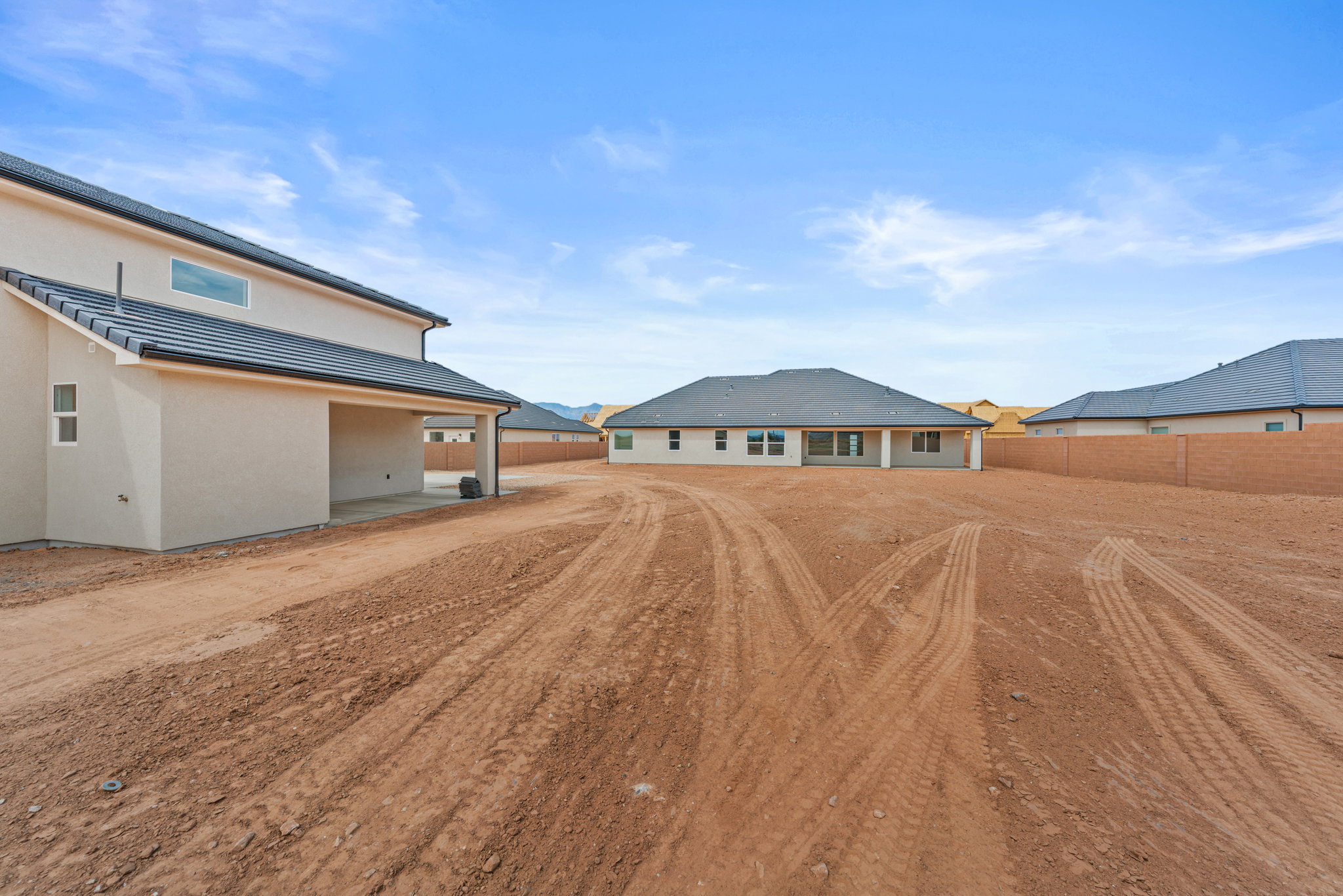 Back of property with stucco siding and a patio