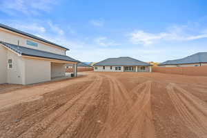 Back of property with stucco siding and a patio