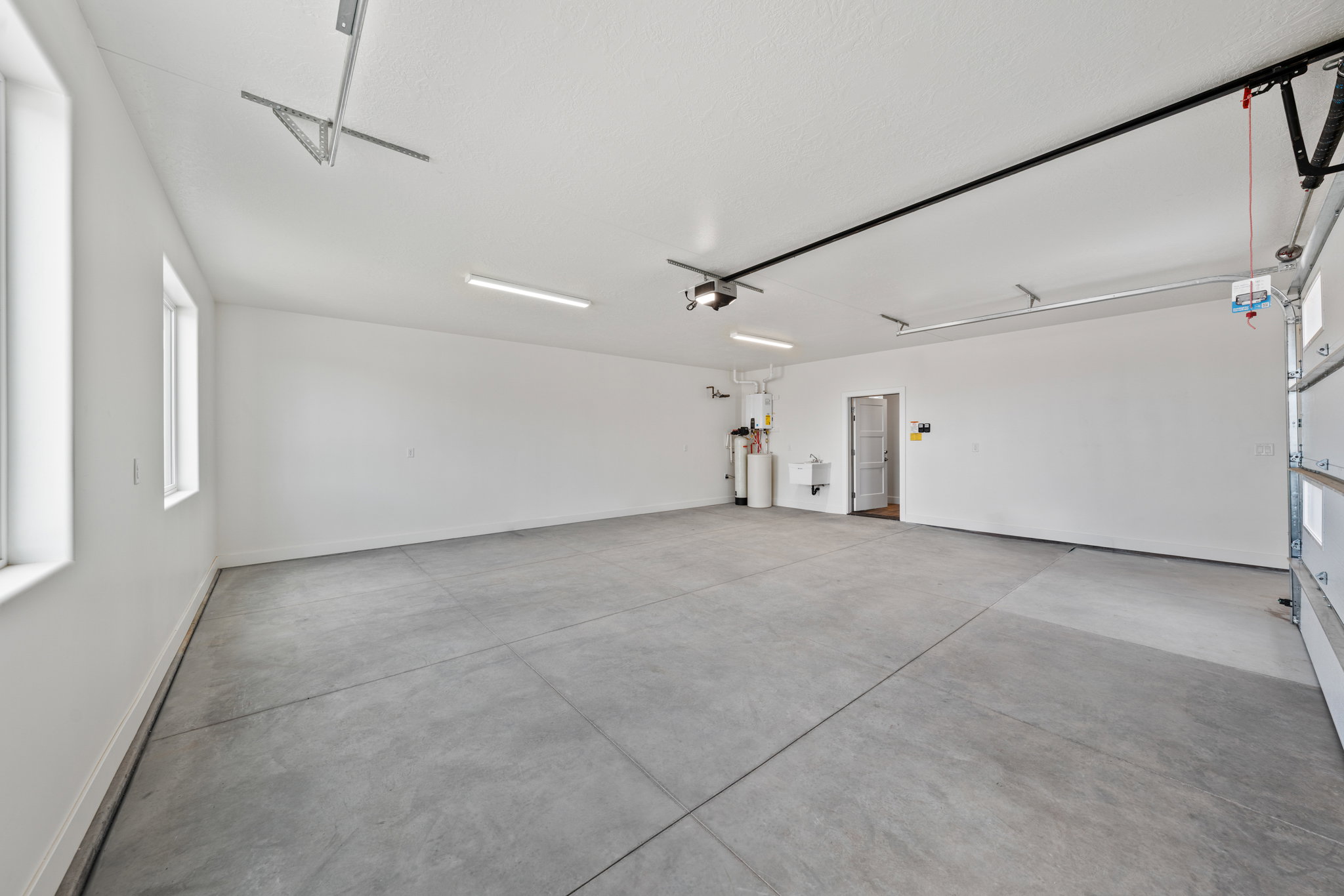 Garage featuring a sink and baseboards