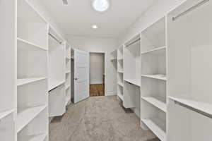 Walk in closet with light carpet