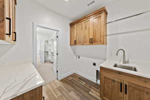 Laundry room with cabinet space, wood tiled floors, hookup for an electric dryer, hookup for a washing machine, and recessed lighting