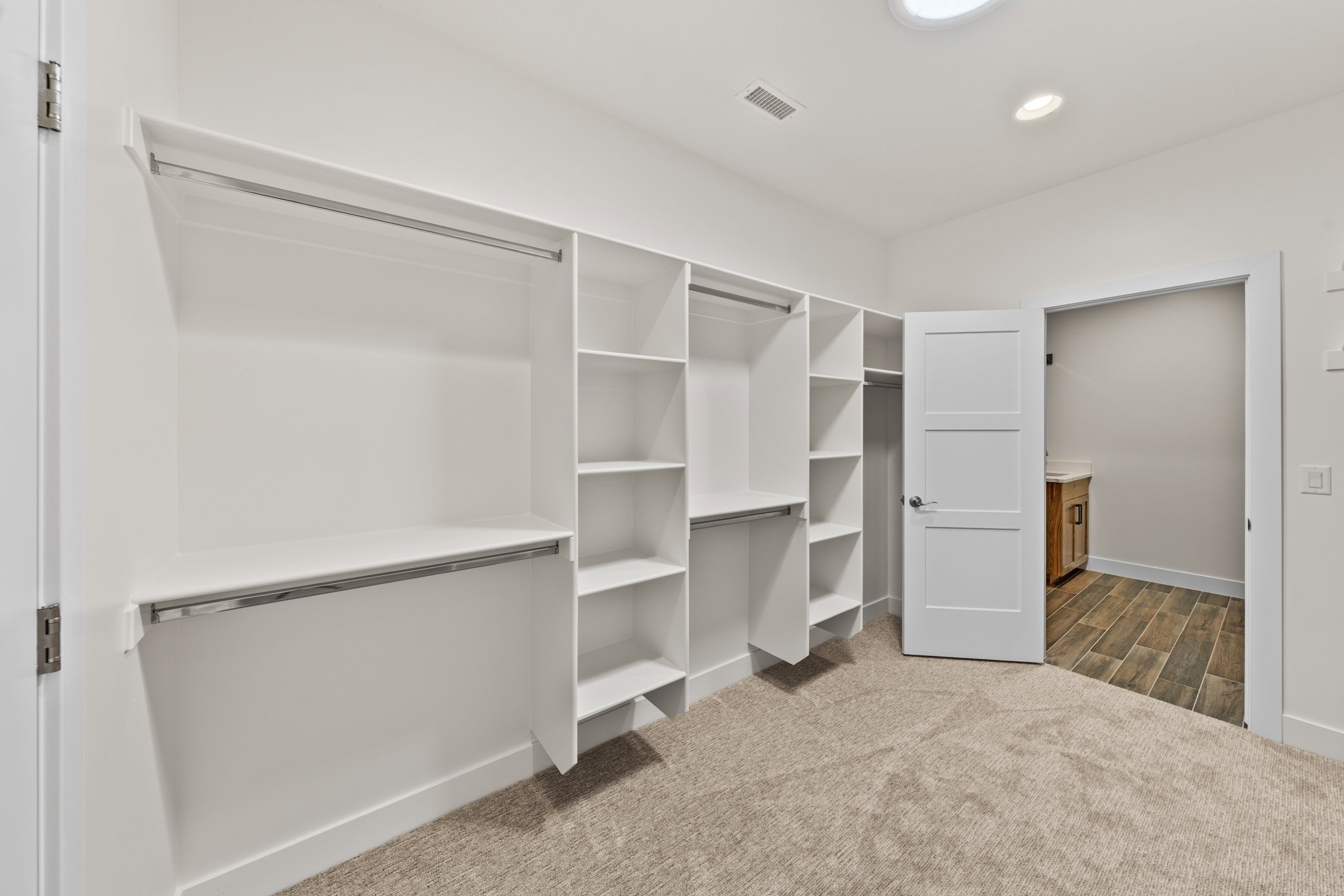 Walk in closet featuring dark colored carpet