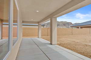 Fenced backyard featuring a patio and a mountain view