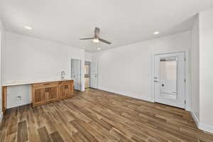 Bar area featuring light countertops, wood finish floors, wood finish cabinetry, ceiling fan, and recessed lighting