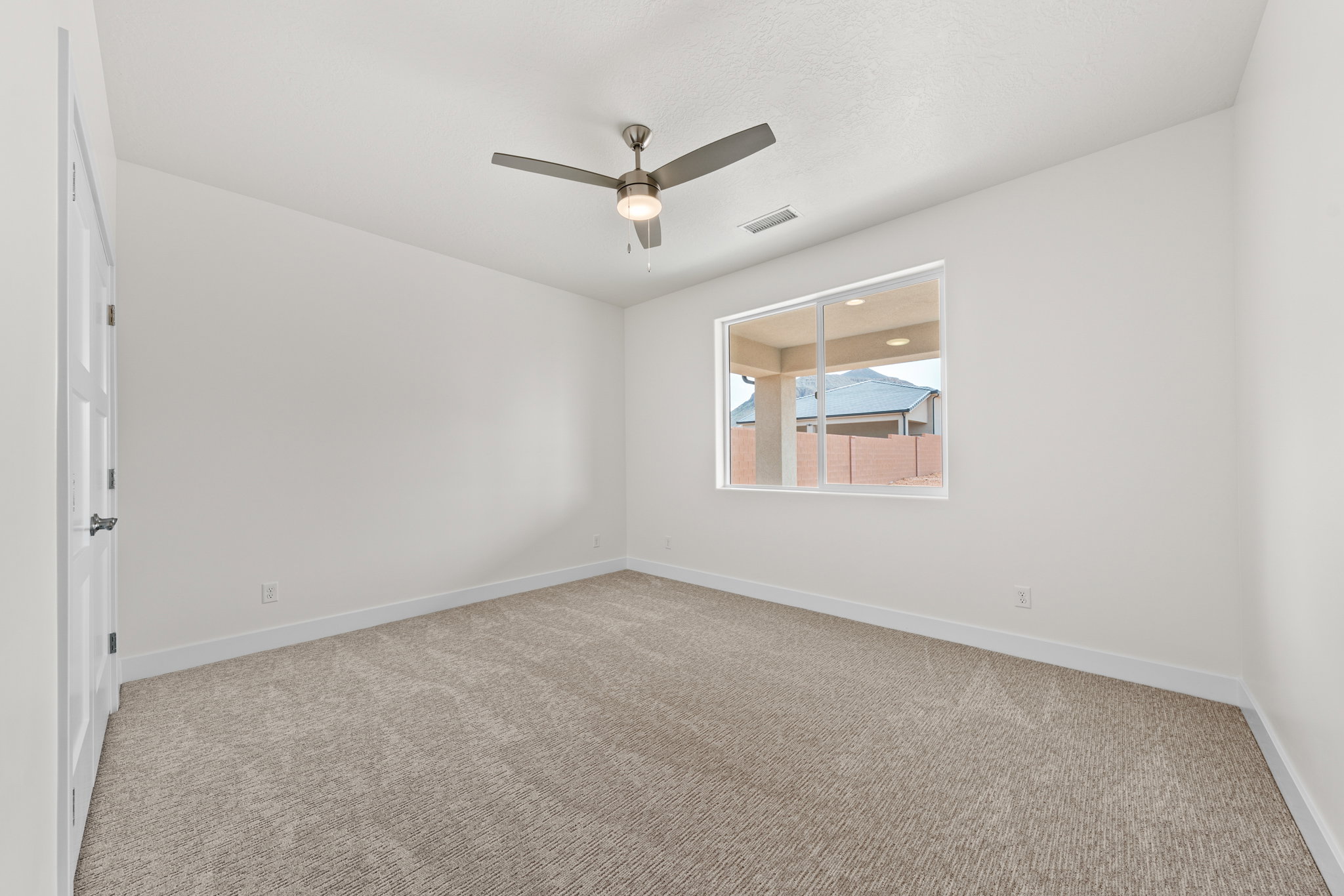 Unfurnished room featuring light carpet and a ceiling fan