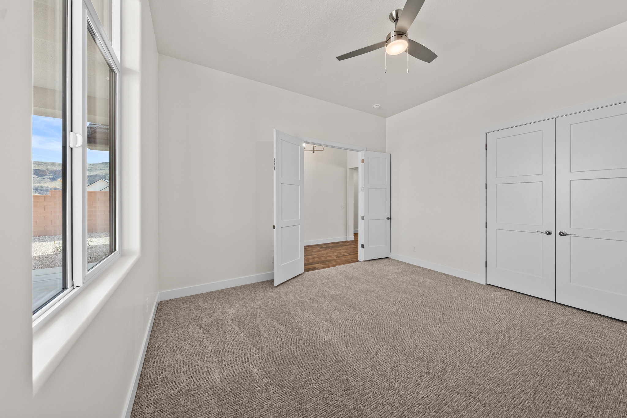 Unfurnished bedroom with carpet, a ceiling fan, and a closet