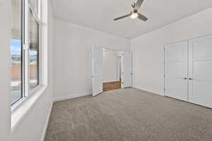 Unfurnished bedroom with carpet, a ceiling fan, and a closet