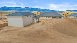 Rear view of house featuring a fenced backyard, a mountain view, stucco siding, and a patio area