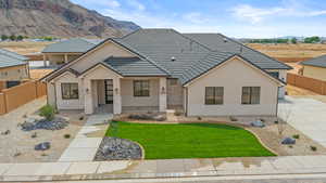 View of front of house featuring a mountain view, stone siding, stucco siding, and a tiled roof