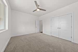 Unfurnished bedroom featuring ceiling fan, carpet flooring, and a closet